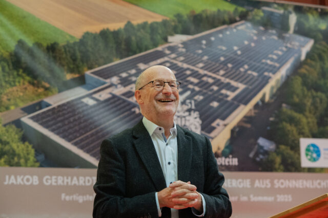 Geschäftsführer Pierre Boos bei der Einweihung vor dem werbeträchtigen Bildhintergrund, der die Solaranlage präsentiert. Foto: Gregor Starosczyk-Gerlach